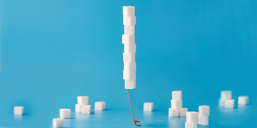 Stack of sugar cubes on blue background