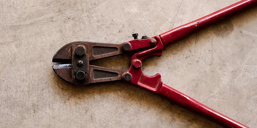 rusted boltcutters with red handle