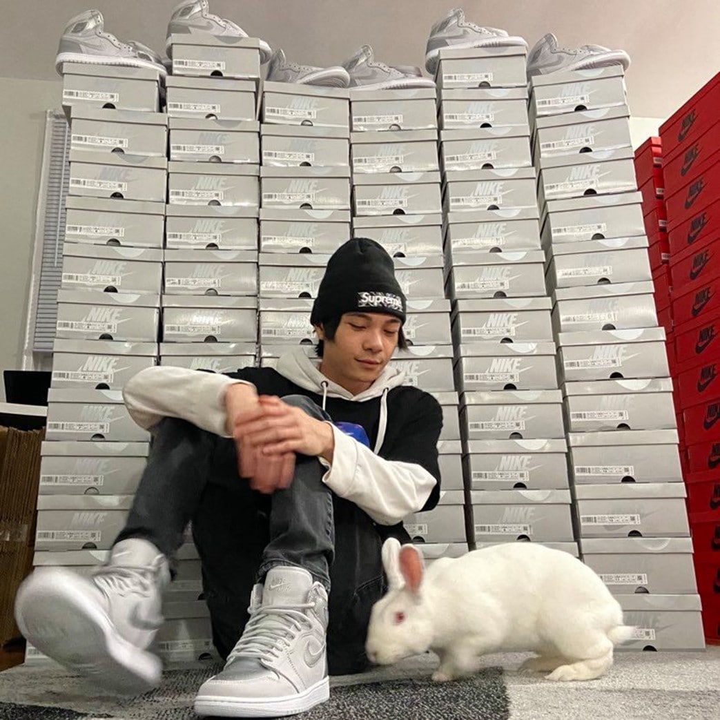 Sneaker botter posing with massive collection of limited edition shoes